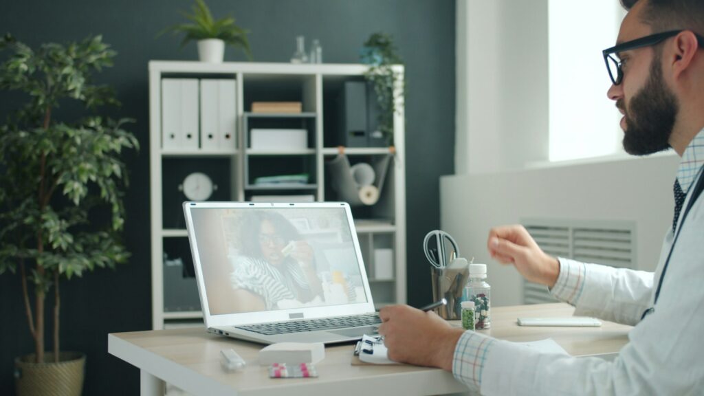 Doctor consulting with a patient by laptop video call